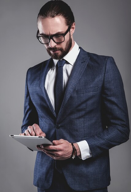 Il ritratto del modello bello dell'uomo d'affari di modo si è vestito in vestito blu elegante con i vetri