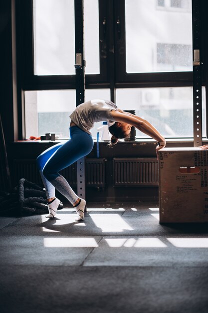 Il ritratto della giovane donna attraente che fa l'yoga o i pilates si esercita