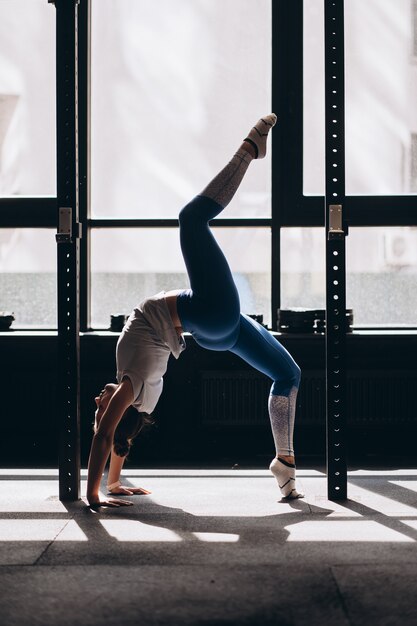 Il ritratto della giovane donna attraente che fa l'yoga o i pilates si esercita