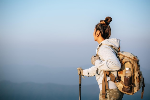 Il ritratto della giovane donna turistica asiatica sta facendo un'escursione sulla cima del montaggio e sta esaminando un bel paesaggio con lo spazio della copia Vacanze di concetto di avventura di Wanderlust dello stile di vita di viaggio all'aperto