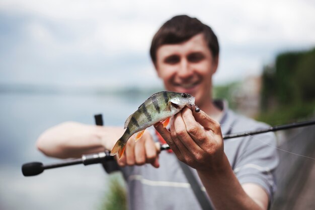 Il ritratto della tenuta dell&#39;uomo ha pescato il pesce nel gancio