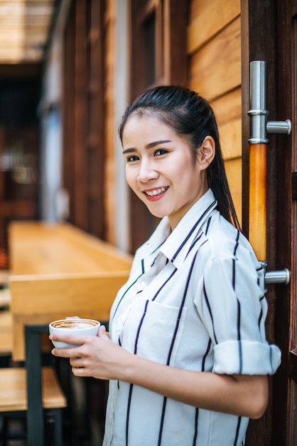 Il ritratto di bella donna asiatica si distende al caffè