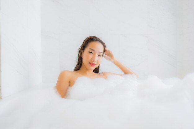 Il ritratto di bella giovane donna asiatica si rilassa nella vasca da bagno