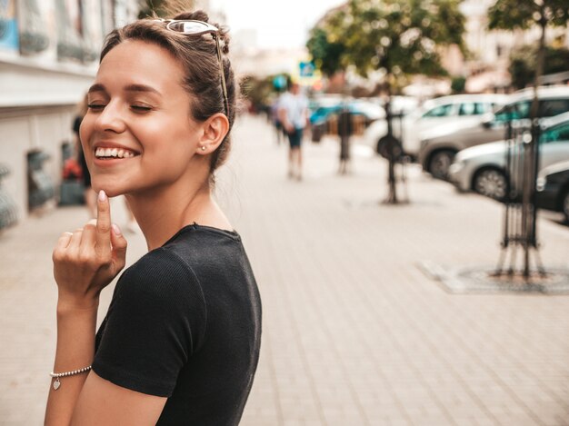 Il ritratto di bello modello sorridente si è vestito in vestiti dell'estate. Ragazza d'avanguardia che propone nella via. Divertimento donna divertente e positiva