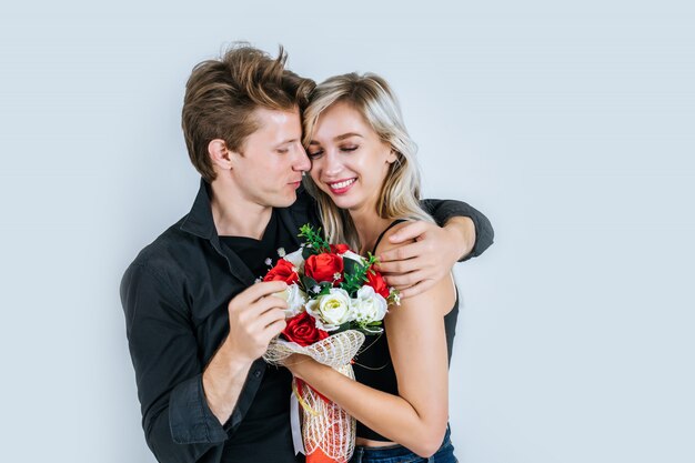 Il ritratto di giovani coppie felici ama insieme al fiore