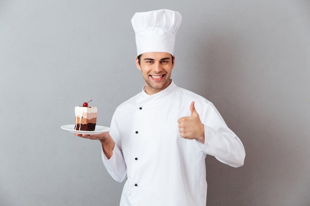 Il ritratto di un cuoco unico maschio sorridente si è vestito in uniforme