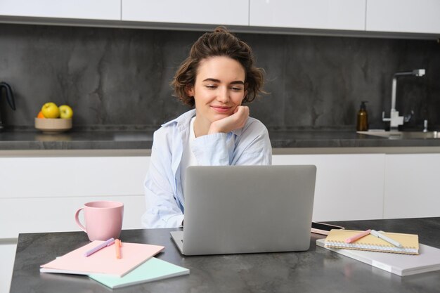 Il ritratto di una giovane donna professionista che lavora da casa guarda gli studi sui laptop online si collega a a