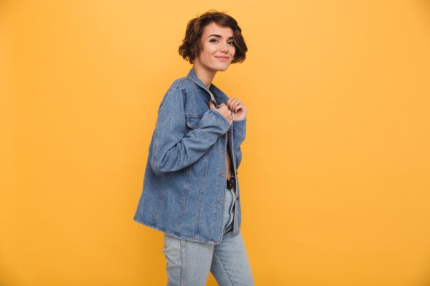 Il ritratto di una giovane donna sorridente si è vestito in giacca di jeans
