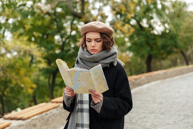 Il ritratto di una ragazza concentrata si è vestito in vestiti di autunno