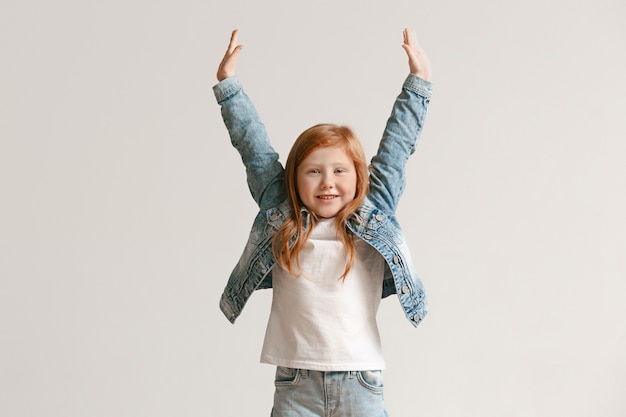 Il ritratto integrale del bambino sveglio nel jeans alla moda copre sorridere