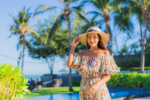 Il sorriso felice della bella giovane donna asiatica del ritratto si rilassa intorno all'oceano tropicale del mare della spiaggia