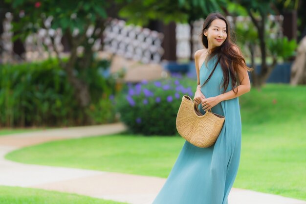 Il sorriso felice della giovane donna asiatica del bello ritratto si rilassa con la passeggiata nel giardino