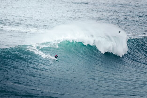 Il surfista professionista cavalca un'onda gigante