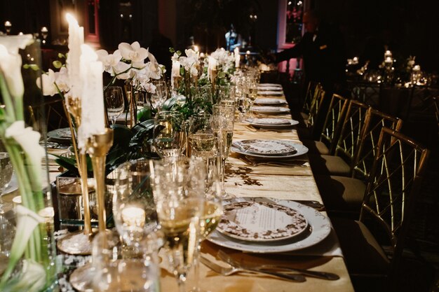 Il tavolo festivo del ristorante è decorato con candele e fiori