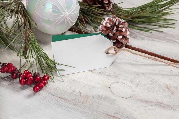 Il tavolo in legno con un cartellino del prezzo vuoto vuoto e decorazioni natalizie.