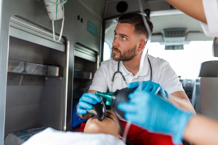 Foto gratuito il team di paramedici ems fornisce assistenza medica al paziente ferito sulla strada per l'assistenza sanitaria assistente per le emergenze ospedaliere utilizzando una maschera di ventilazione non invasiva in un'ambulanza primo piano