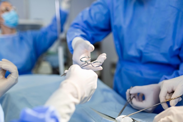 Foto gratuito il team medico e infermieristico sta eseguendo un'operazione chirurgica al pronto soccorso dell'assistente ospedaliero distribuisce forbici e strumenti ai chirurghi durante l'operazione