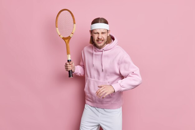 Il tennista concentrato tiene la racchetta pronta per iniziare il gioco vestito con abbigliamento sportivo non vuole sconfiggere si prepara per la competizione sportiva.