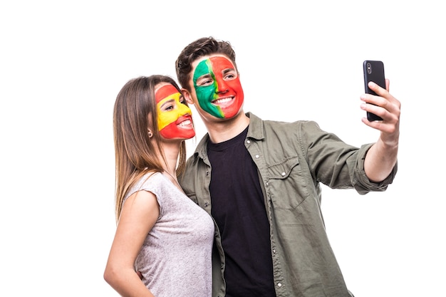 Il tifoso del sostenitore dell'uomo bello della squadra nazionale del Portogallo ha dipinto la faccia della bandiera prendere selfie con il fan del sostenitore della donna della squadra nazionale della Spagna Fans le emozioni.