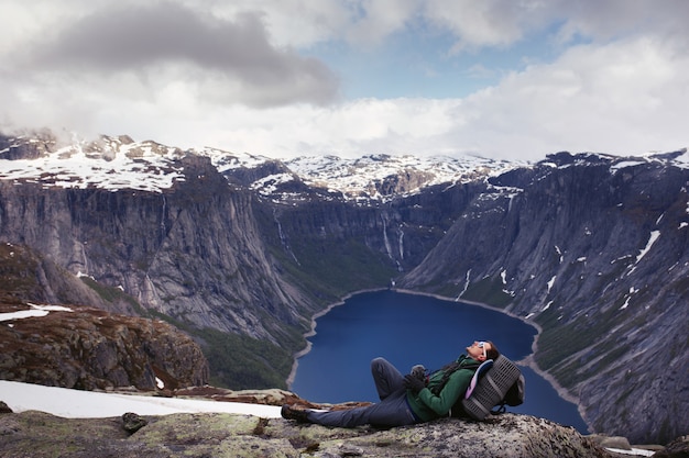 Il turista riposa prima di bella vista sul lago della montagna da qualche parte in Norvegia