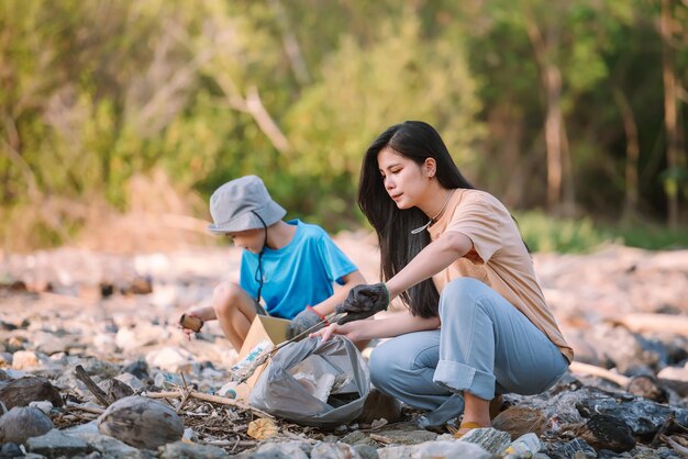 Il volontario per la conservazione dell'ambiente familiare asiatico aiuta a mantenere e ripulire i rifiuti di plastica e schiuma sulla spiaggia e nell'area della foresta di mangrovie Concetto di volontariato