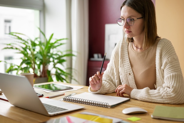 Illustratore femminile adulto che lavora su un dispositivo tablet