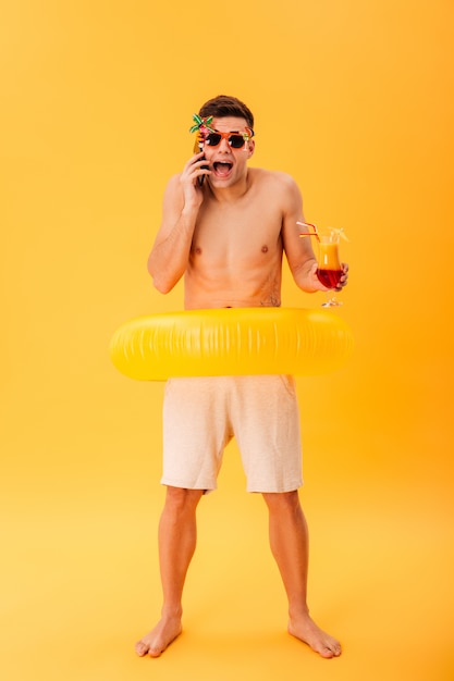 Immagine a figura intera dell'uomo urlando nudo in pantaloncini e occhiali da sole