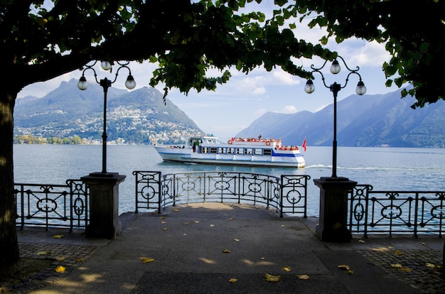 Immagine affascinante di un veliero contro le montagne nebbiose a Lugano, Svizzera