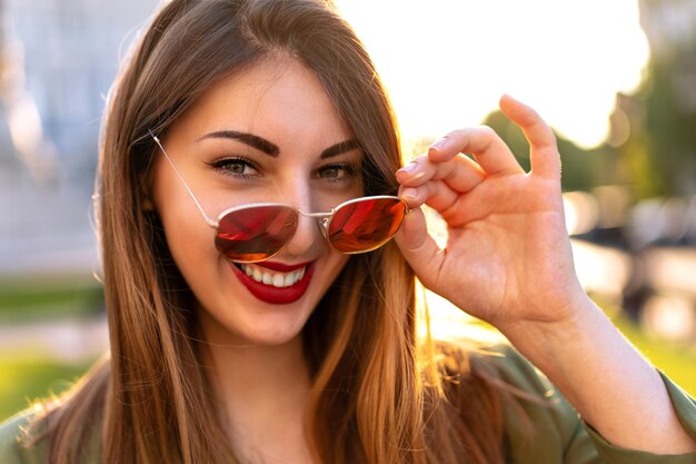 Immagine all'aperto di una donna alla moda alla moda in posa per strada, vestito elegante da donna d'affari, giornata di sole.