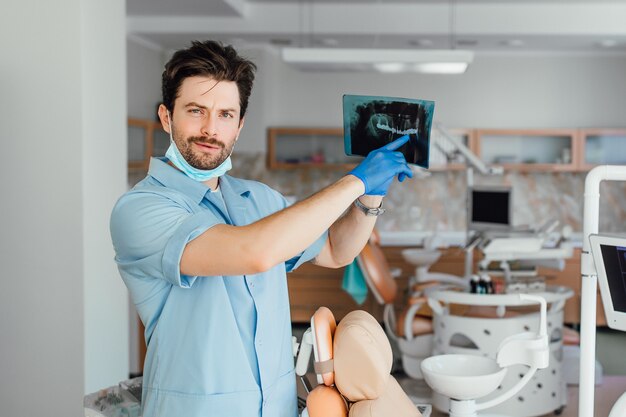 Immagine del medico o del dentista maschio che esamina i raggi x, nel suo ufficio.