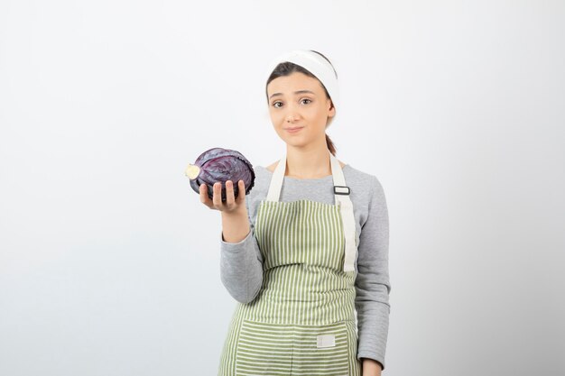 Immagine della donna dispiaciuta che posa con cavolo viola su bianco