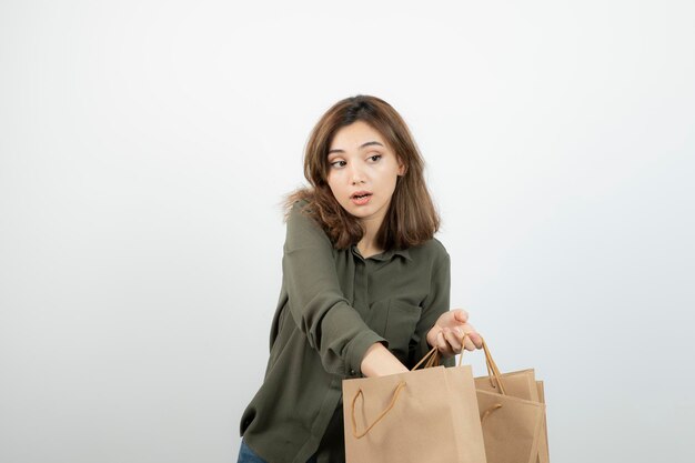 Immagine di bella donna che toglie qualcosa dalla borsa artigianale. Foto di alta qualità