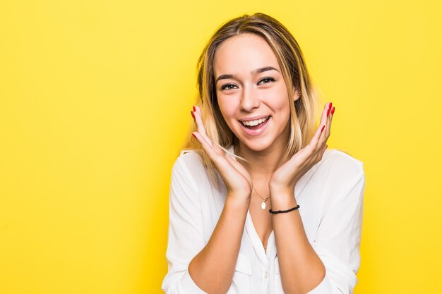 Immagine di eccitato urlando giovane donna in piedi isolato su muro giallo.