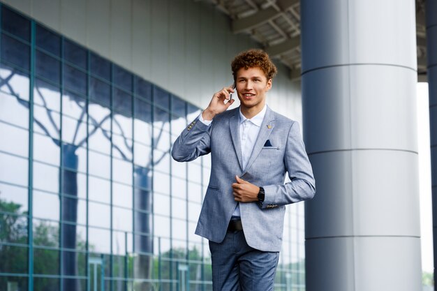 Immagine di giovane uomo d'affari dai capelli rossi che parla sul telefono