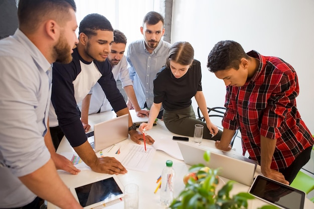 Immagine di impiegati seri ed esecutivi che fanno il loro lavoro nella sala del consiglio in officeinterior Uomini d'affari che lavorano a tavola rotonda in ufficio Business plan e concetti di progetto aziendale