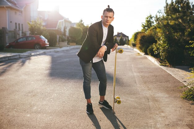 Immagine di un uomo con longboard andando sulla strada