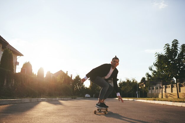 Immagine di un uomo con longboard andando sulla strada