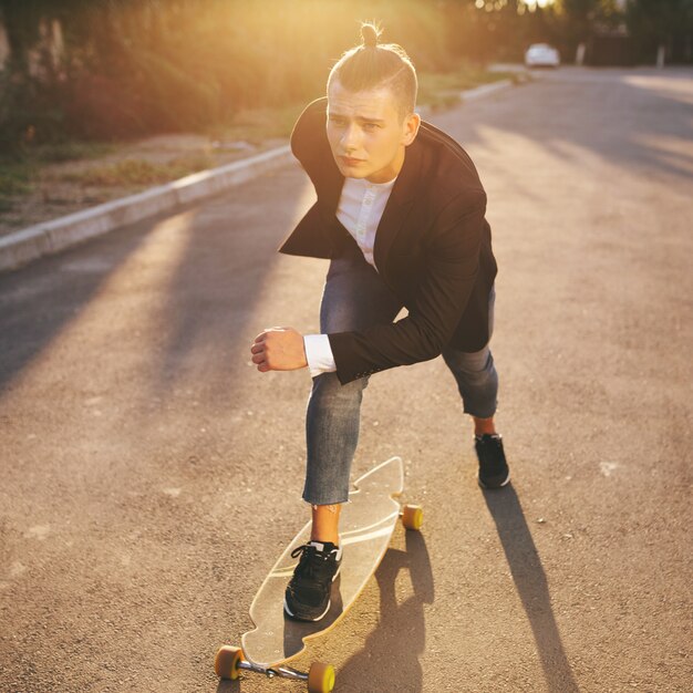 Immagine di un uomo con longboard andando sulla strada