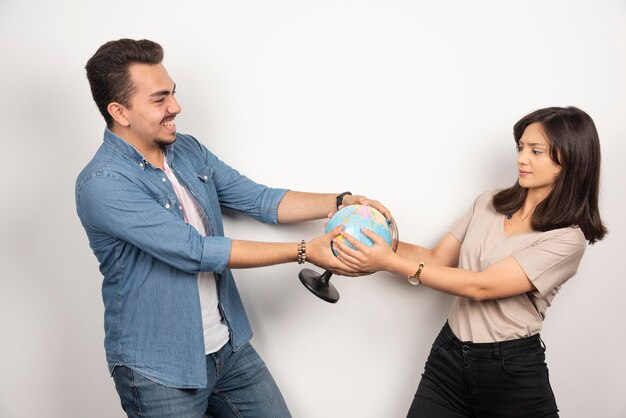 Immagine di un uomo e di una donna che tiene il globo terrestre.