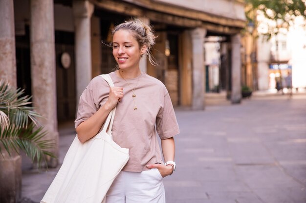 Immagine di una bella donna per strada che cammina con la borsa