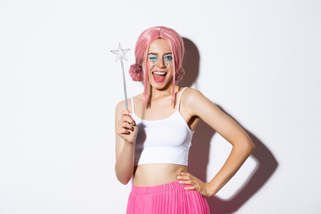 Immagine di una bellissima fata con una parrucca rosa che tiene in mano una bacchetta magica e sorride, celebrando halloween