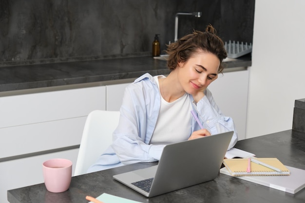 Immagine di una giovane donna produttiva che lavora da casa, fa studi a distanza, impara corsi online su di lei.