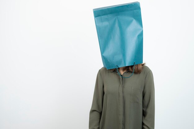 Immagine di una giovane ragazza che mette la testa all'interno della borsa artigianale. Foto di alta qualità