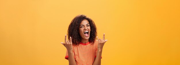 Immagine di vita di una donna afro-americana felice e elegante che si sente fantastica, che sguazza alla festa, che urla.