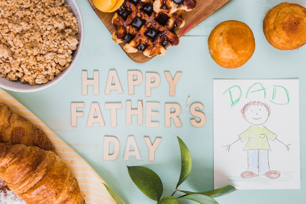 Immagine e pasticceria vicino alla scrittura di festa del papà felice