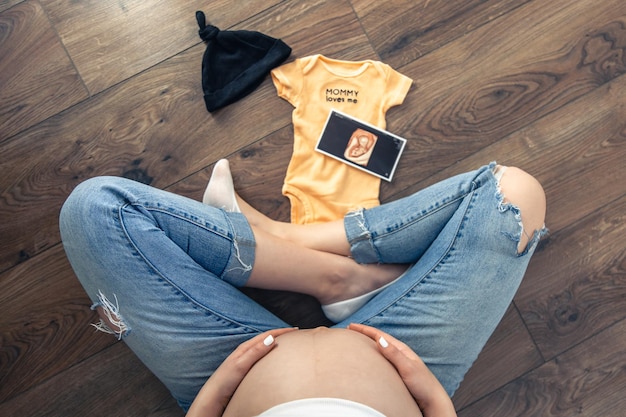 Immagine ecografica della donna incinta e roba per bambini una madre si aspetta un bambino