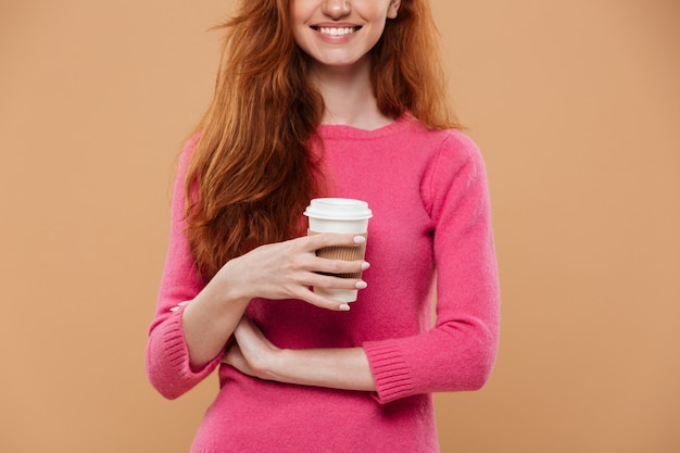 Immagine potata di una tazza di caffè sorridente della tenuta della ragazza della testarossa