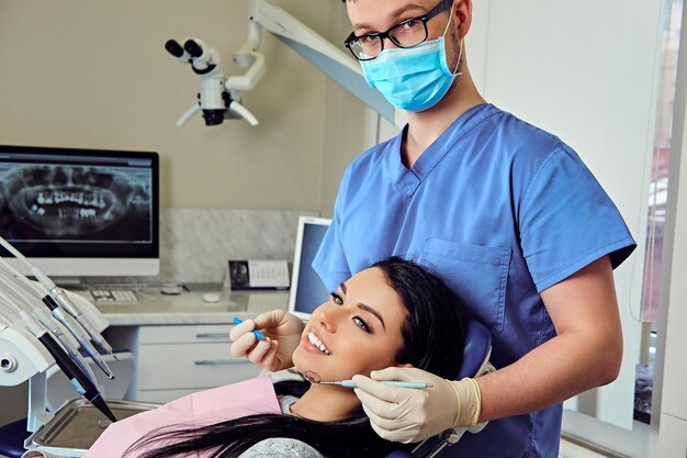 Immagine ravvicinata di un dentista che esamina i denti della femmina in odontoiatria.