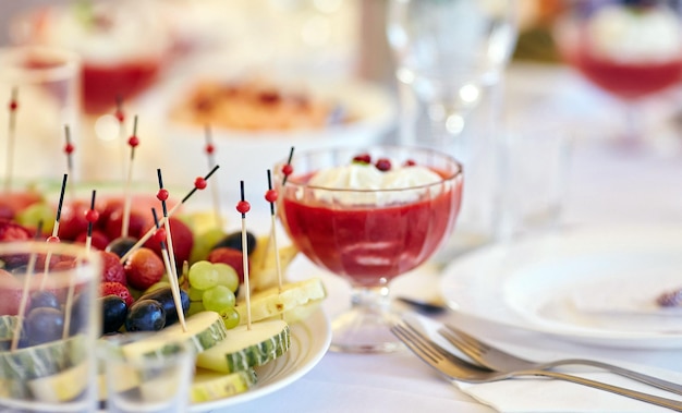 Immagine ravvicinata di un tavolo festivo con frutta a fette e dessert. Evento festivo, festa o ricevimento di nozze.