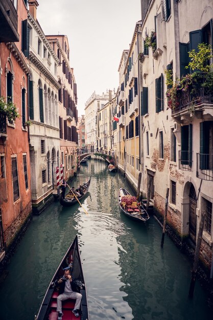 Immagine verticale delle gondole sul canal grande tra edifici colorati a Venezia, Italia